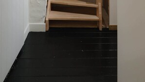 A wooden staircase with a black floor, white walls, and a white door. - Spacious 3-Level Apartment in Mechelen (Mechelen)