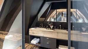 Une salle de bain moderne avec un grand miroir, un meuble-lavabo en bois et un revêtement de sol en marbre.