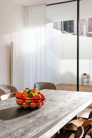 A dining area with a wooden table, a fruit bowl, and chairs. - Wonderful City home in Antwerp (Antwerpen)