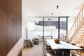 A modern dining area with a large table, chairs, and a view through large windows. - Wonderful City home in Antwerp (Antwerpen)