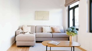A modern living room with a sofa, ottoman, and a coffee table. - Magnificent 3BR home in Antwerp (Antwerpen)