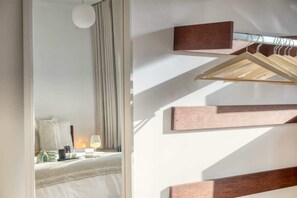 A hotel room with a bed, a bedside table with a lamp, and a wall-mounted wooden rack. - Cozy Retreat in Antwerp with balcony (Antwerpen)