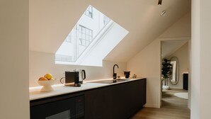 A modern kitchen with a skylight, a dishwasher, and a sink. - Spacious Suite for 4 with Kitchenette (Antwerpen)