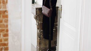 A room with a brick wall, a white door, and a coat rack with a bag. - Bright 1-Bedroom Apartment with Balcony in Antwerp (Antwerpen)