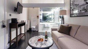 Ett modernt vardagsrum med ett soffbord i marmor, en soffa, en tv och en balkong med utsikt.