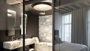 A modern bathroom with a marble sink, a large mirror, and a glass-enclosed shower. - Secret & private suite with timeless elegance (Antwerpen)