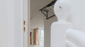 A staircase leading to a bedroom with a bed, a window with curtains, and a radiator. - Cozy Hideaway Near the Heart of Antwerp (Antwerpen)
