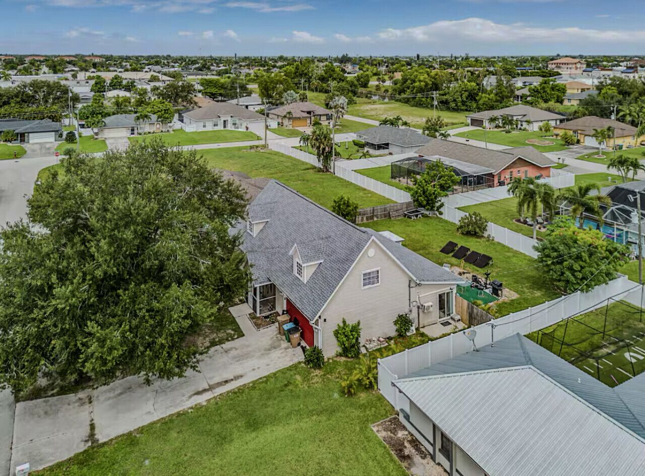 Un quartier résidentiel avec des maisons, de belles pelouses verdoyantes et un ciel dégagé.