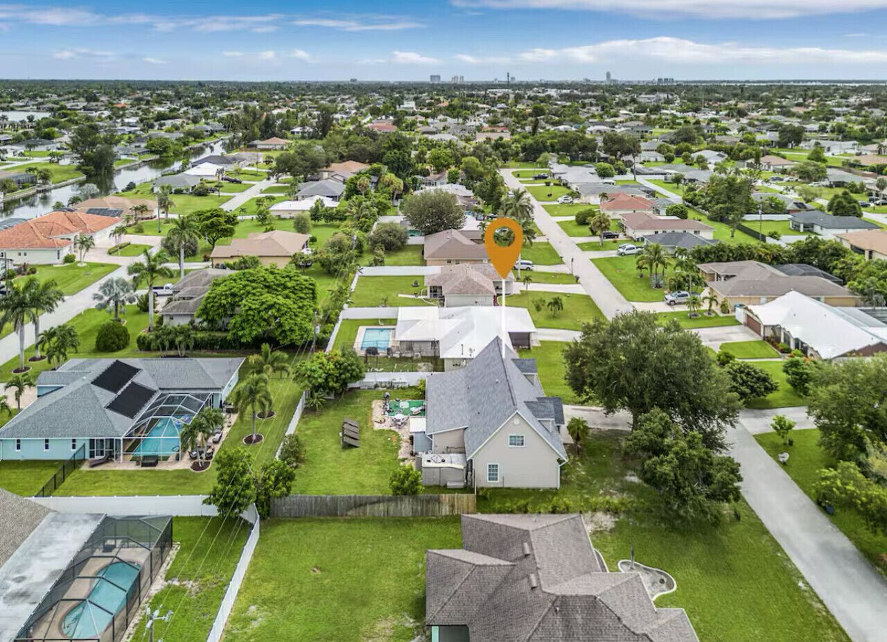 Zona residencial con casas, una piscina y una casa grande señalada con un icono de ubicación.