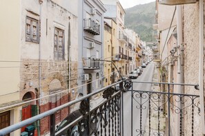 A narrow street with buildings on either side, balconies, and a clear view of the street. - Apartment 'La Luna' with Private Terrace, Balcony and Air Conditioning (Castellammare del Golfo)