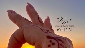 Uma mão com desenhos de henna ao pôr do sol.