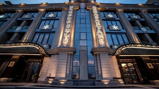 A grand building with two illuminated signs reading "AGHABABYANS" and a central entrance with a decorative column.