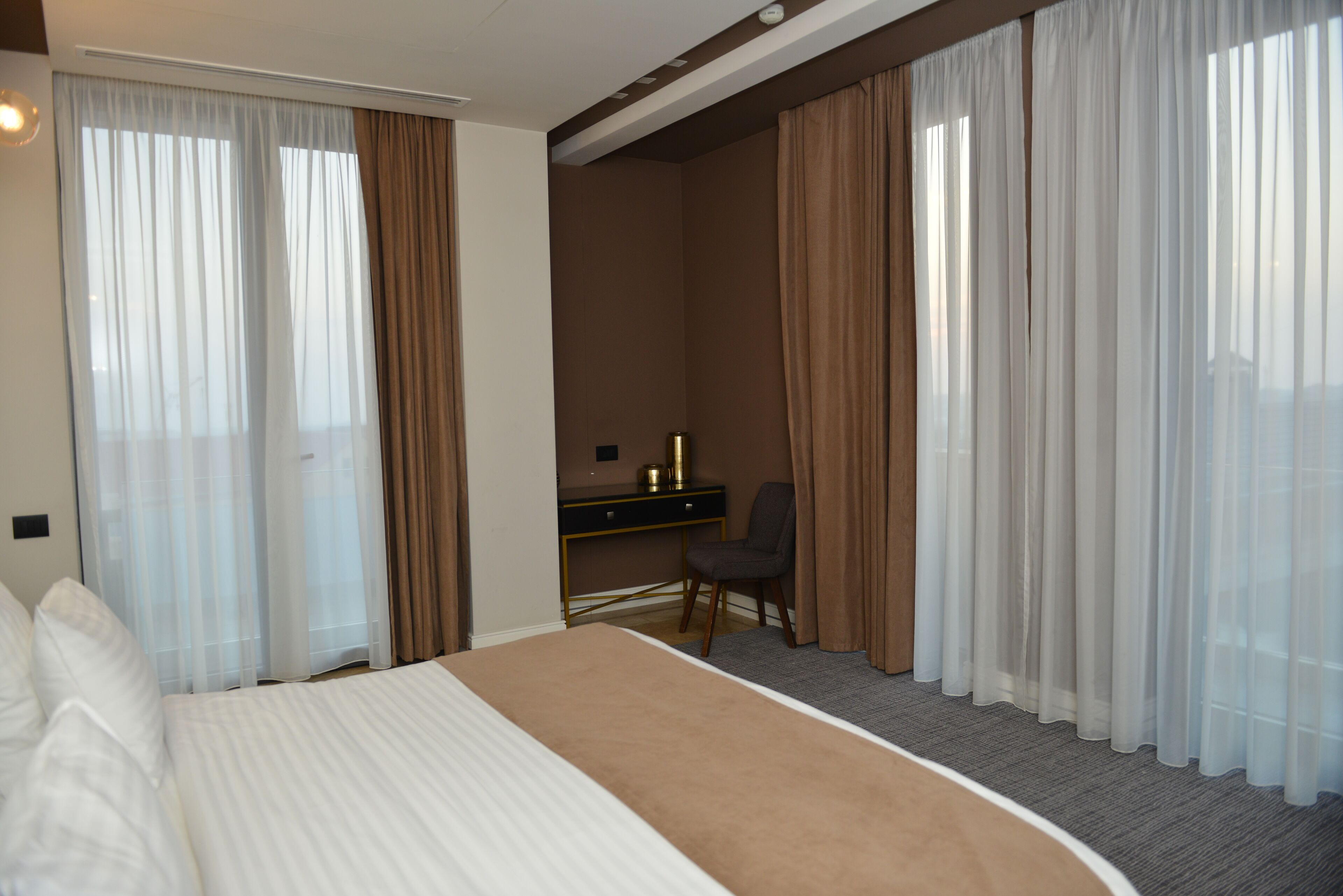 Ein Hotelzimmer mit einem großen Bett, einem Schreibtisch und einem Stuhl.