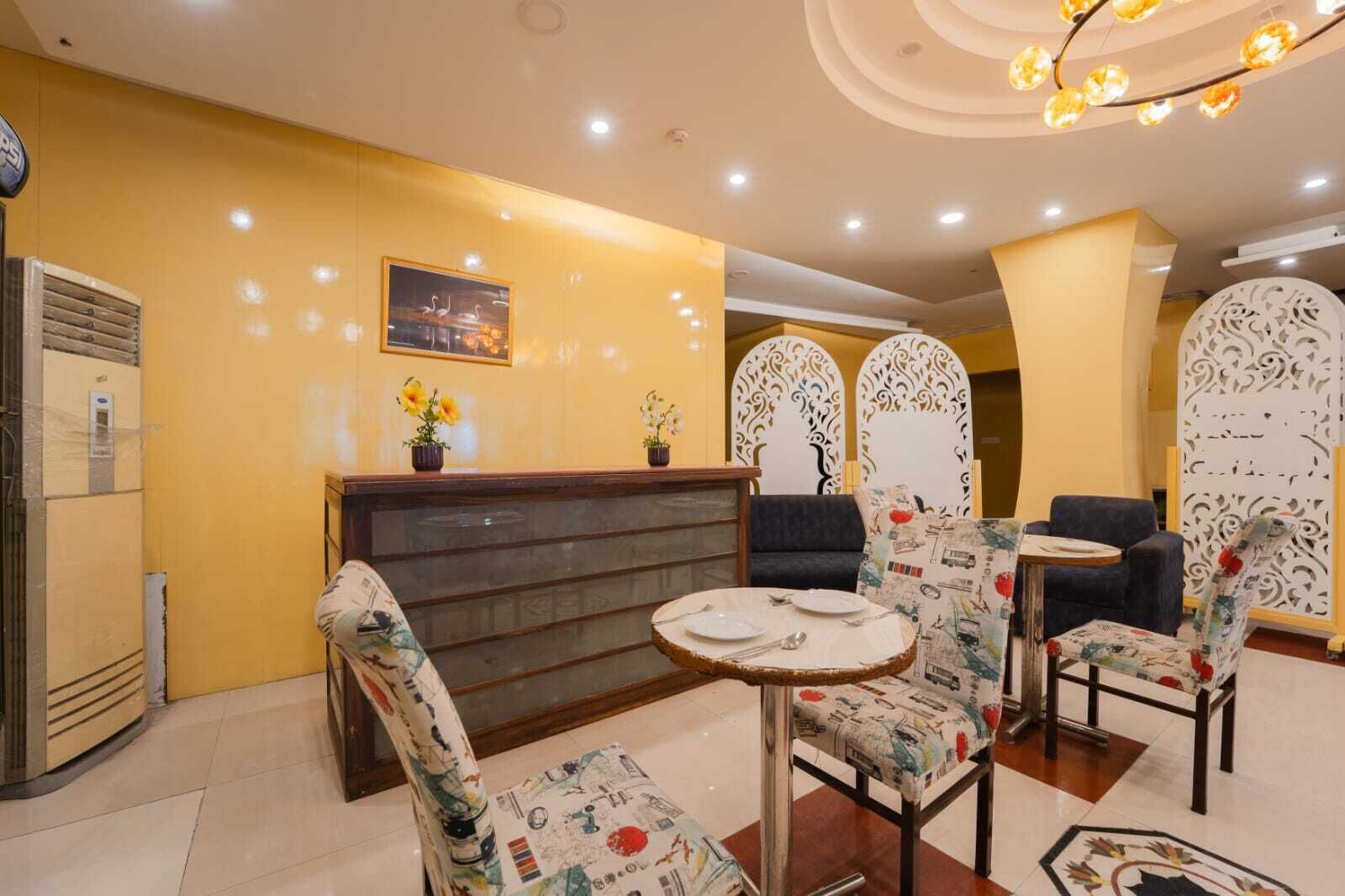 A reception area with a wooden reception desk, patterned chairs, and a round table.