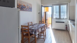 A compact kitchen with a dining table, chairs, and a refrigerator. - CHECK-INGANNI, above MM1 Inganni and next to the Italian Diagnostic Center (Milano)