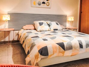 A neatly arranged bedroom with a bed, bedside tables, and a wall-mounted artwork. - Haus Filippa mit Entspannungsterrasse by Interhome (Balestrate)