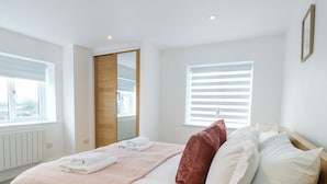 A bedroom with a bed, pillows, and a window. - Glynllifon 6 (Marianglas)