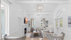 Un salón amplio con chimenea, asientos cómodos y un televisor grande.