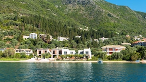 A coastal village with houses on a hillside, a beach, and a body of water. - Acqua di Mare - Villa Siena (Perigiali)