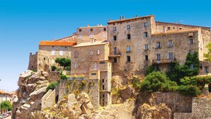 A historic stone building with multiple balconies and a steep stone staircase leading up to it. - Stylish Villa with Heated Pool steps from the Beach and Restaurant (Olmeto)