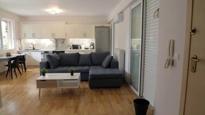 Uma sala de estar moderna com um sofá seccional, uma mesa de centro e um espaço de jantar com mesa e cadeiras.