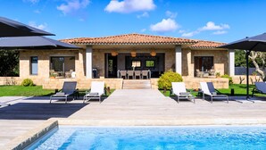 A house with a pool, outdoor seating, and a stone facade. - Stylish Signature Villa with Heated Pool close to the Beach (Pianottoli-Caldarello)