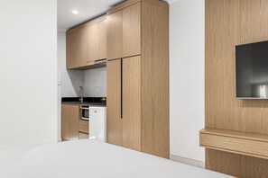A modern kitchen with wooden cabinets, a built-in oven, and a microwave.