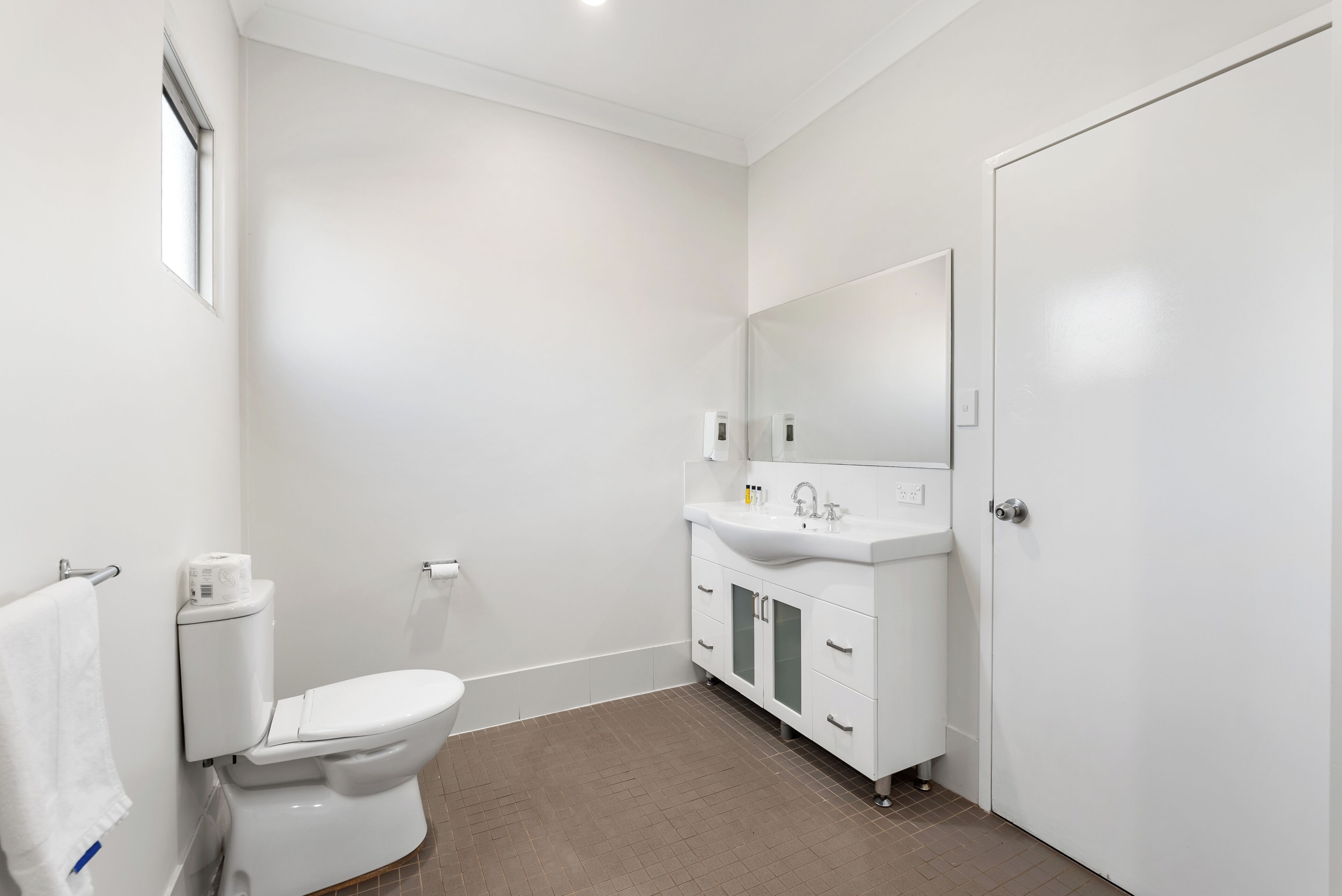 Ein modernes Badezimmer mit Toilette, Waschbecken und Spiegel.