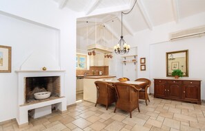 Eine geräumige Küche mit Essbereich, Kamin und einer Chandelier.
