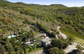 Ein Steinhaus, umgeben von Weinbergen und einem Swimmingpool.