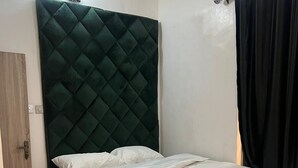 Una habitación con cama, una puerta y una cortina.