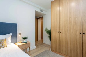 A bedroom with a bed, bedside table, lamp, and a wardrobe. - A quietly luxurious three-bedroom in Chamartín, Madrid's most upscale family neighborhood, close to the northern business district and well connected to the rest of the city. (MADRID)