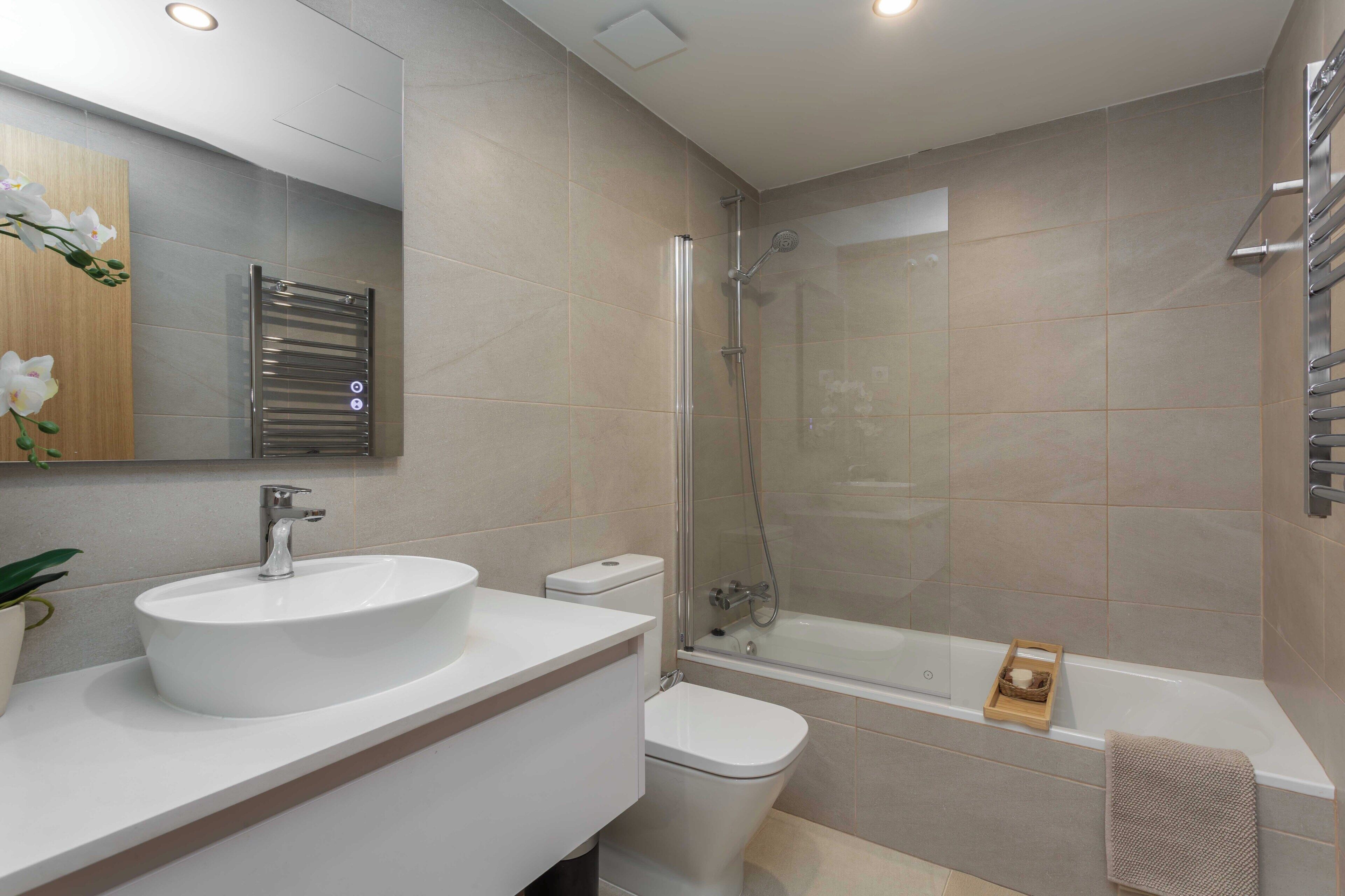 Un baño moderno con lavamanos, inodoro y bañera.