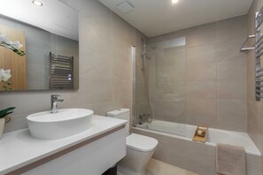 Ein modernes Badezimmer mit Waschbecken, Toilette und Badewanne.