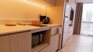 Eine moderne Küche mit Holzausstattung, einer eingebauten Mikrowelle und einer Kaffeemaschine.