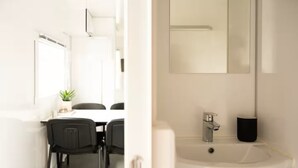 A modern bathroom with a white sink, a mirror, and a black trash can. - Mobile Home Park (Strendur)