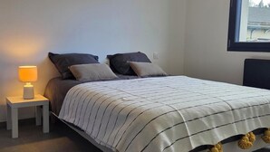 A bedroom with a bed, a bedside lamp, and a window. - COZY APARTMENT IN FORMIGUERES, SLEEPS 6–8 (Formiguères)