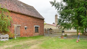 A brick building with a red-tiled roof, a wooden door, and a small window. - Holiday Home Fechter with Shared Terrace, Garden, and Wi-Fi in Lanz (Lanz)