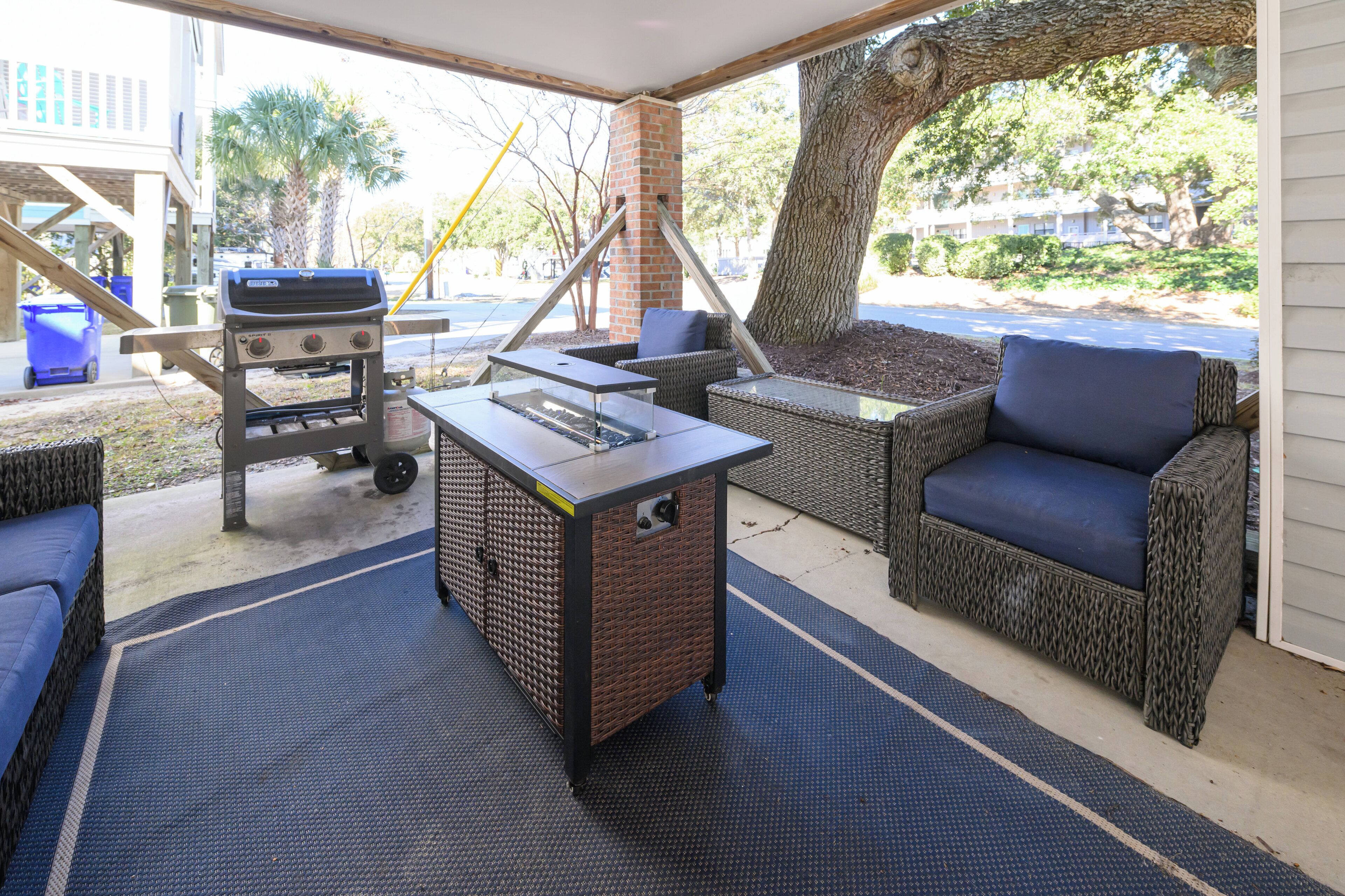 Une terrasse extérieure aménagée avec des meubles en osier, un barbecue et une table.