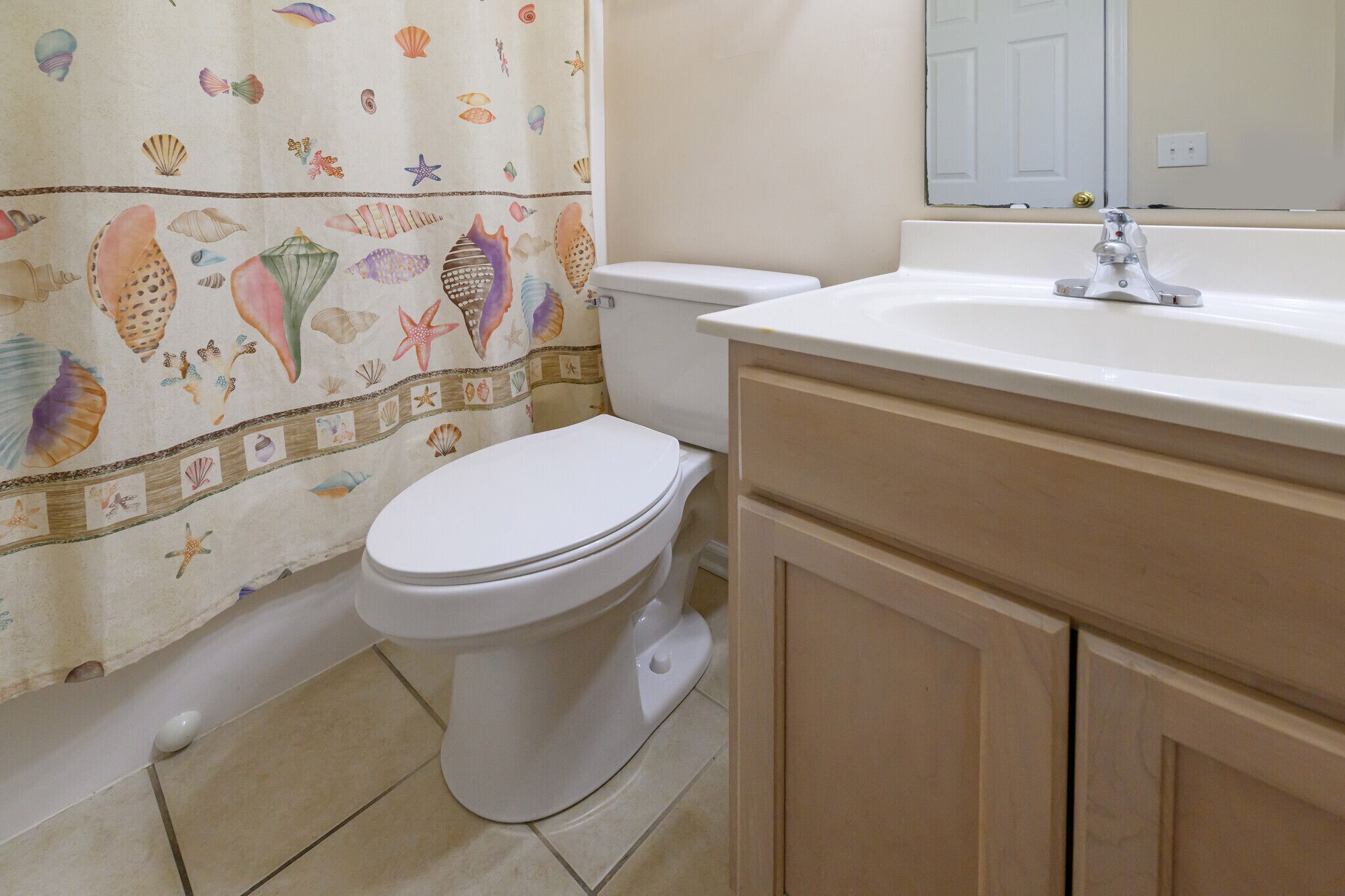 Een badkamer met toilet, wastafel en kast.