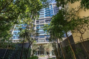 A multi-story residential building with balconies, surrounded by trees and a fence. - Condominium w/ Complete Leisure Facilities and Unbeatable Location in POA - Bles (Porto Alegre)