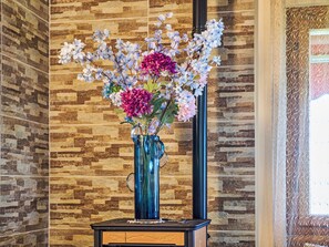 A vase with flowers on a wooden table against a stone wall. - Bella Viesta by Interhome (Albisano)