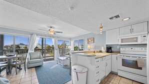 A spacious kitchen with a large island, white cabinets, and a built-in microwave. - GS Plantation West - RCC -1254 (Gulf Shores)