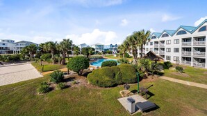 A resort with multiple-story buildings, a swimming pool, and well-maintained lawns. - GS Plantation West - RCC -1254 (Gulf Shores)