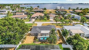 Un quartier résidentiel avec des maisons, une piscine et une vue sur l’eau.