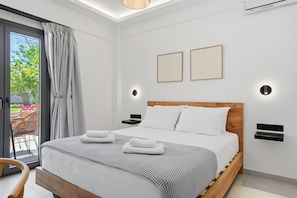 Een moderne hotelkamer met een houten bed, wit beddengoed, twee wandlampen en uitzicht door een glazen deur.