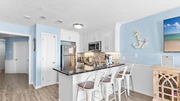 Condo com design assinado, 1 quarto, sacada, vista para a praia | Cozinha privada | Geladeira, micro-ondas, fogão, cooktop