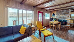 A cozy cabin interior with a wooden interior, a dining area, and a view of the outdoors. - Prop House | Wallowa lakefront home w/dock (Joseph)
