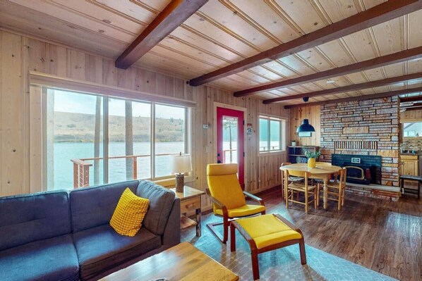 A cozy cabin interior with a wooden interior, a dining area, and a view of the outdoors.