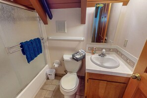 A bathroom with a toilet, sink, and shower area.